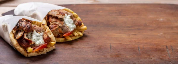 Shawarma、ジャイロ ピタを奪う、屋台の食べ物。木製のテーブルに伝統的なギリシャ トルコ料理、肉料理 — ストック写真