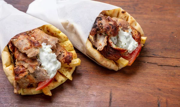 Gyro pita, shawarma, comida callejera. Griego tradicional turco, comida de carne en la mesa de madera — Foto de Stock