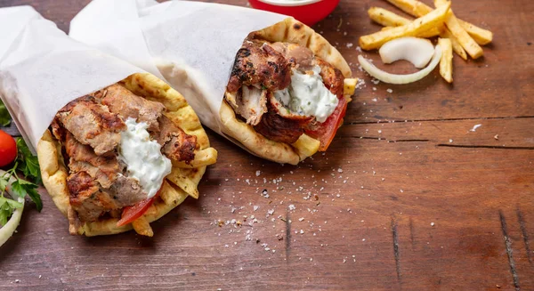 Shawarma、ジャイロ ピタを奪う、屋台の食べ物。木製のテーブルに伝統的なギリシャ トルコ料理、肉料理 — ストック写真