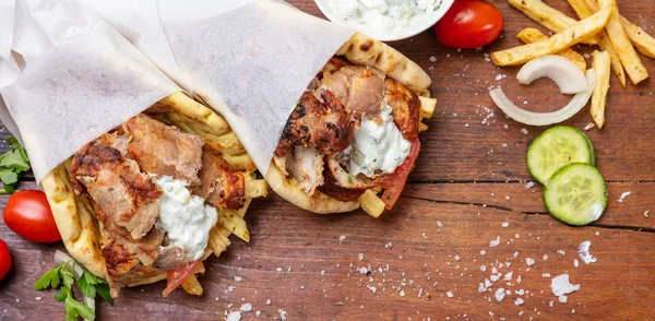 Shawarma、ジャイロ ピタを奪う、屋台の食べ物。木製のテーブルに伝統的なギリシャ トルコ料理、肉料理 — ストック写真
