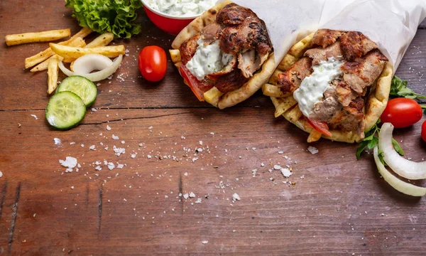 Gyro pita, shawarma, jedzenie na wynos, ulica. Tradycyjne greckie potrawy tureckie, mięsa na drewnianym stole — Zdjęcie stockowe