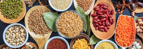 Variedade de legumes secos não cozidos em colheres de madeira, banner — Fotografia de Stock