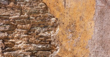 Eski, taş duvar, cephe bina sıkıntılı. Duvar, doku arka plan renk turuncu boyalı ve solmuş,