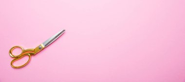 Pembe arka planda altın kolu ile makas, banne, kopya alanı, üst görünüm