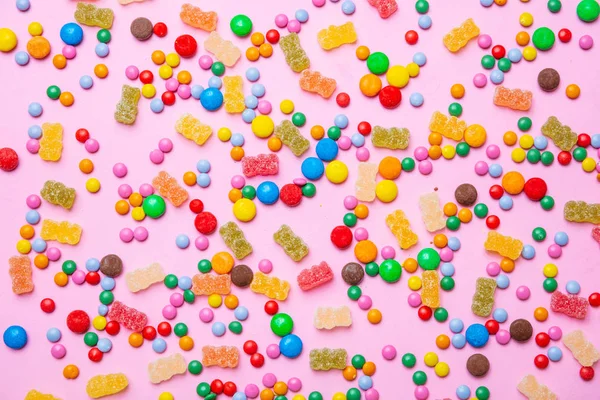 Концепция дня рождения. Красочные сладкие конфеты на розовом фоне — стоковое фото