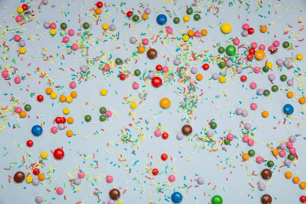 Verjaardag concept. Kleurrijke hagelslag en snoepjes op blauwe pastel achtergrond — Stockfoto