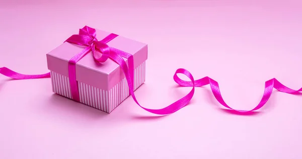 분홍색 배경에 리본 선물 상자입니다. 생일 선물 컨셉. — 스톡 사진