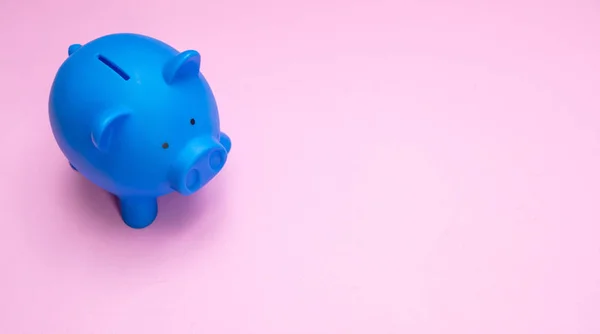 Sparschwein blaue Farbe vor pastellrosa Hintergrund — Stockfoto