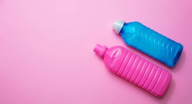 Pembe arka planda kumaş yumuşatıcı ve deterjan pembe ve mavi renk,