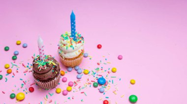 Pastel pembe kopya alanı mum ile iki doğum günü cupcakes.