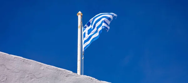 Grécia símbolo nacional. Bandeira grega acenando no fundo do céu azul — Fotografia de Stock