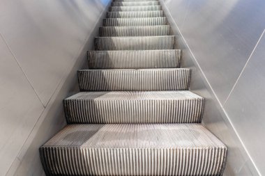 Empty electric escalators going up, stainless steel finishings, closeup view clipart