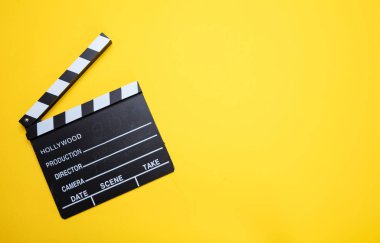 Sarı renkli arka plan üzerinde film clapperboard, üst görünüm