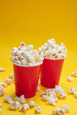 Sarı renk arka plan üzerinde kırmızı kağıt bardak pop mısır