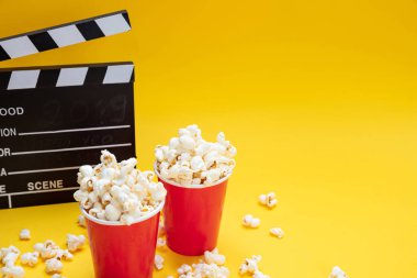 Sarı renk arka plan üzerinde Clapperboard ve pop mısır