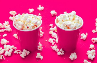 Pembe renk arka plan üzerinde kırmızı kağıt bardak pop mısır