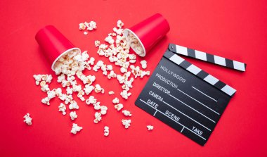 Kırmızı renk arka plan üzerinde Clapperboard ve pop mısır, üst görünümü
