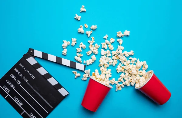 Clapperboard ve mavi renk arka plan üzerinde pop mısır, üst görünümü