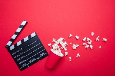 Kırmızı renk arka plan üzerinde Clapperboard ve pop mısır, üst görünümü
