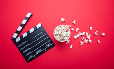 Kırmızı renk arka plan üzerinde Clapperboard ve pop mısır, üst görünümü