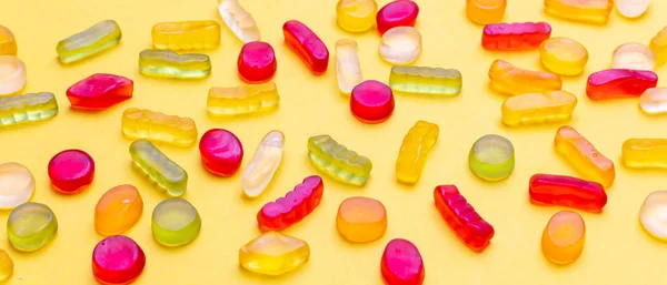 Gelée colorée bonbons assortiment sur fond de couleur jaune, vue rapprochée — Photo