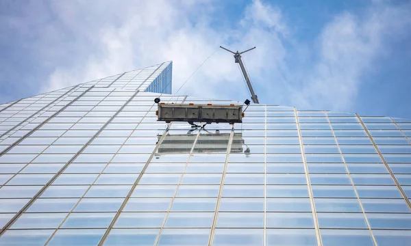 Nova Iorque, Manhattan. Serviços de limpeza de vidro, fachada de vidro de construção alta, vista de baixo contra o fundo do céu azul — Fotografia de Stock