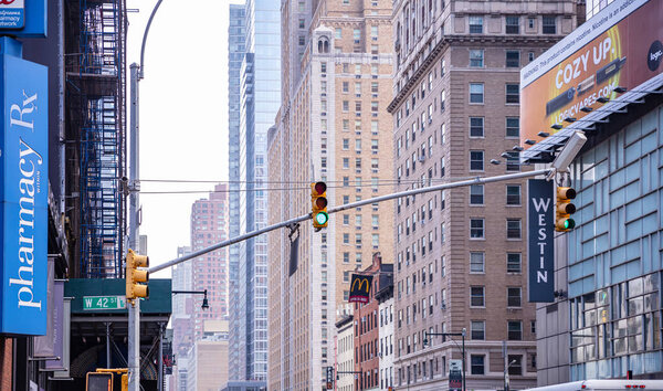 New York, USA. May 2nd, 2019. Green traffic lights for cars hanging in the city center, High office buildings background