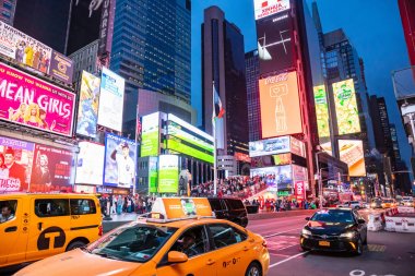 New York, Broadway sokakları geceleri. Işıklı yüksek binalar, renkli neon ışıklar, reklamlar ve bekleyen insanlar