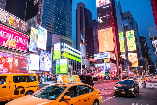 New York, breite Straßen in der Nacht. erleuchtete hohe Gebäude, bunte Neonlichter, Werbung und wartende Menschen — Stockfoto