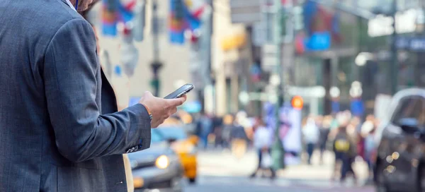 New York, Wall Street. Junger Mann im Anzug mit Smartphone — Stockfoto