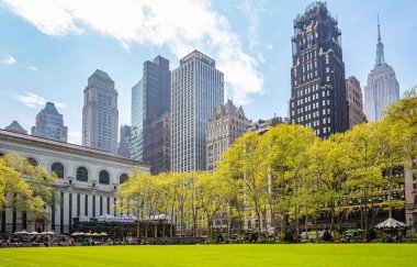 Bryant Parkı, New York, Manhattan. Yüksek binalar mavi gökyüzü arka plan, ilkbaharda güneşli bir gün karşı aşağıdan görünümü