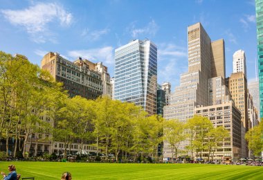 Bryant Parkı, New York, Manhattan. Yüksek binalar mavi gökyüzü arka plan, ilkbaharda güneşli bir gün karşı aşağıdan görünümü