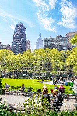 Bryant Parkı, New York, Manhattan. İnsanlar rahatlatıcı, ilkbaharda güneşli bir gün