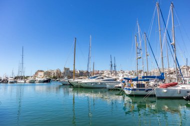 Marina Zeas Pire, Yunanistan. Birçok demirli yat. Teknelerin yansıması, mavi sakin deniz, şehir ve gökyüzü arka plan.