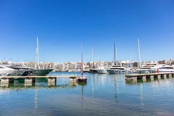 Marina Zeas in Piraeus, Greece. Many moored yachts. Reflection of boats, blue calm sea, city and sky background. — Stock Photo, Image