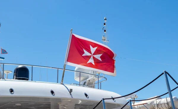 Vecchia bandiera maltese sulla poppa del traghetto. Crociera in corso verso le isole. sfondo cielo blu, vista da vicino . — Foto Stock