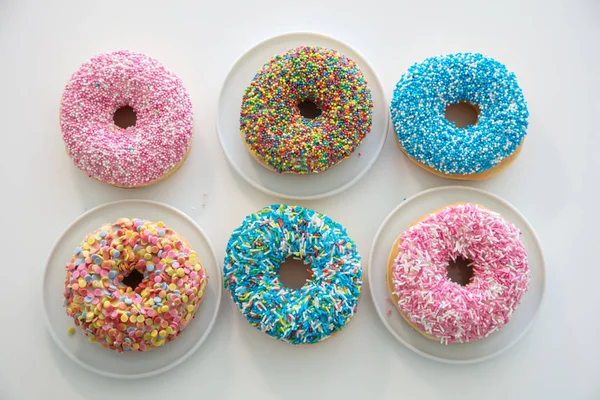 Rosquillas con decoración colorida sobre fondo de color blanco. Vista superior — Foto de Stock