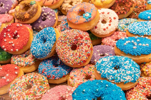 Doughnuts met kleurrijke decoratie achtergrond. Close-upweergave — Stockfoto