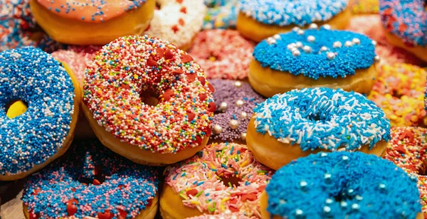 Doughnuts met kleurrijke decoratie achtergrond. Close-upweergave — Stockfoto