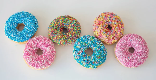 Donut met kleurrijke decoratie op witte kleur achtergrond. Top View — Stockfoto