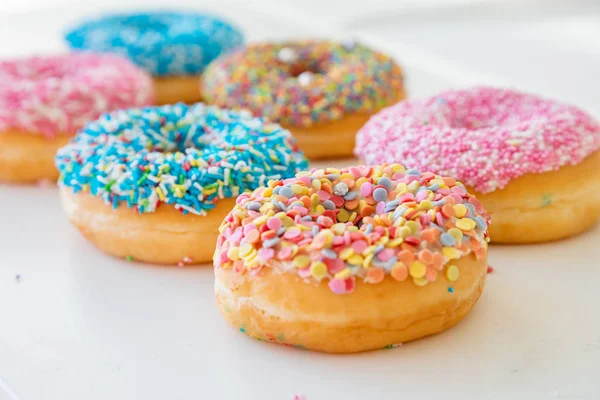 Donuts variados em branco. Vista de perto — Fotografia de Stock