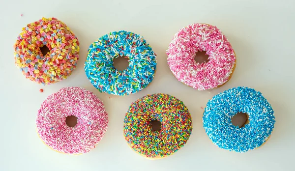 Donut met kleurrijke decoratie op witte kleur achtergrond. Top View — Stockfoto