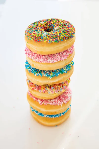 Rosquillas con decoración colorida sobre fondo de color blanco. Vista superior — Foto de Stock