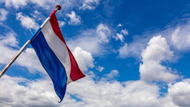Hollanda bayrağı bulutlarla mavi gökyüzüne el sallıyor