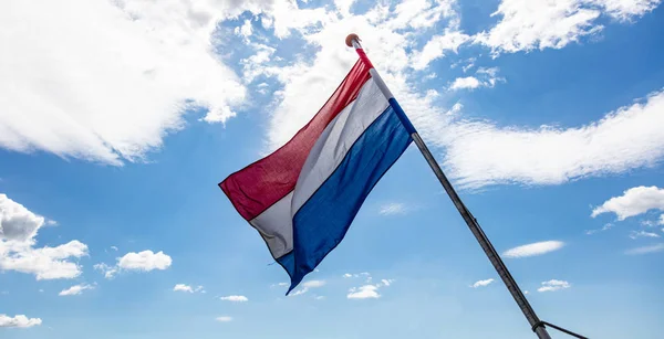 Ολλανδική σημαία που κουνώντας το γαλάζιο του ουρανού με σύννεφα — Φωτογραφία Αρχείου