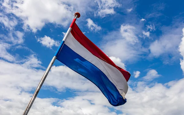 Ολλανδική σημαία που κουνώντας το γαλάζιο του ουρανού με σύννεφα — Φωτογραφία Αρχείου