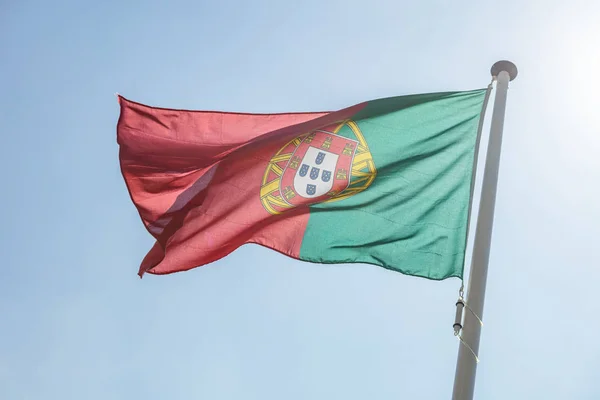 Portugal vlag zwaaiende tegen heldere blauwe hemel — Stockfoto