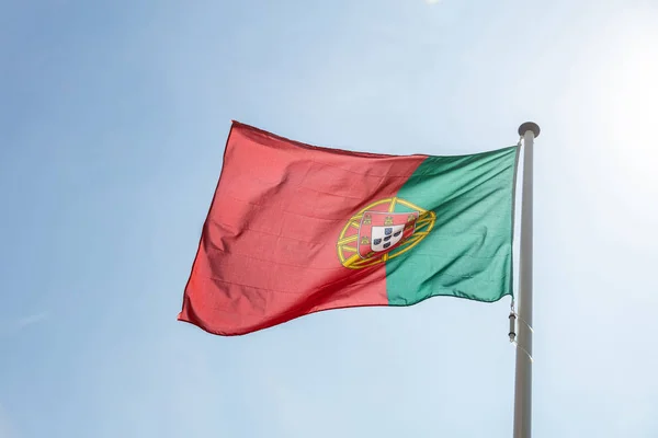 Portekiz bayrağı açık mavi gökyüzüne karşı sallayarak — Stok fotoğraf