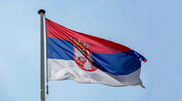 Bandera de Serbia ondeando contra el cielo azul claro —  Fotos de Stock