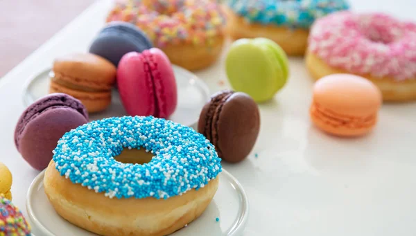 Donuts und Macarons auf Holz, Nahaufnahme mit Details — Stockfoto